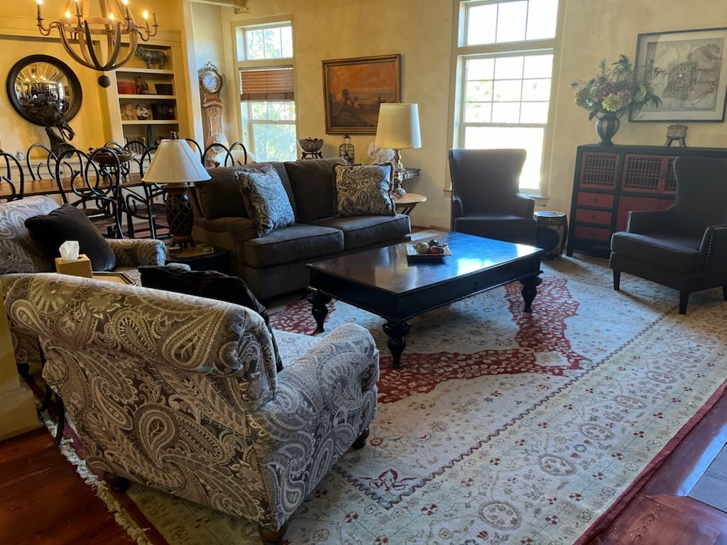 A cozy living room featuring comfortable seating, a coffee table, and large windows allowing natural light.