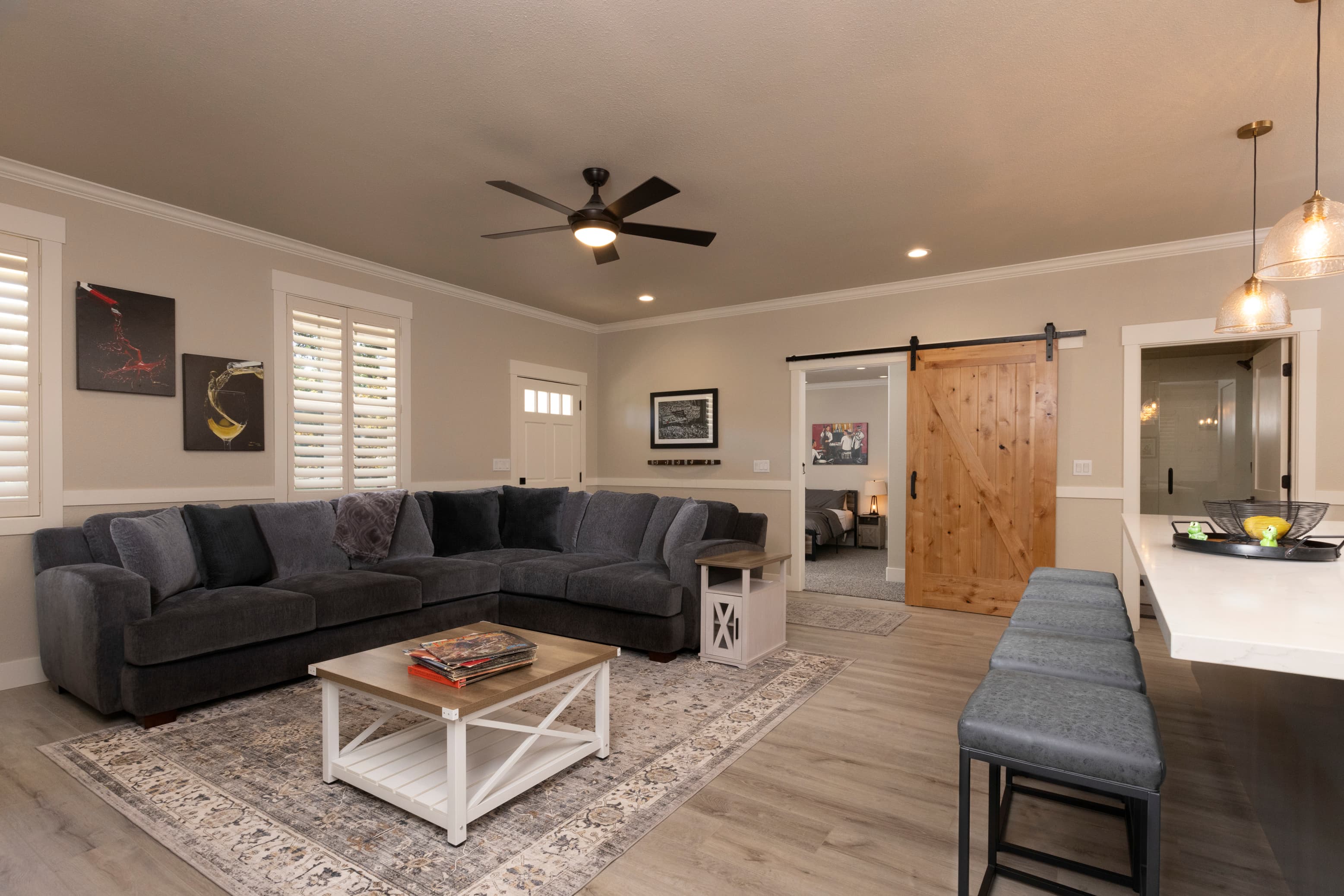 A cozy living room featuring a large gray sectional sofa, a white coffee table, and a sliding wooden door.
