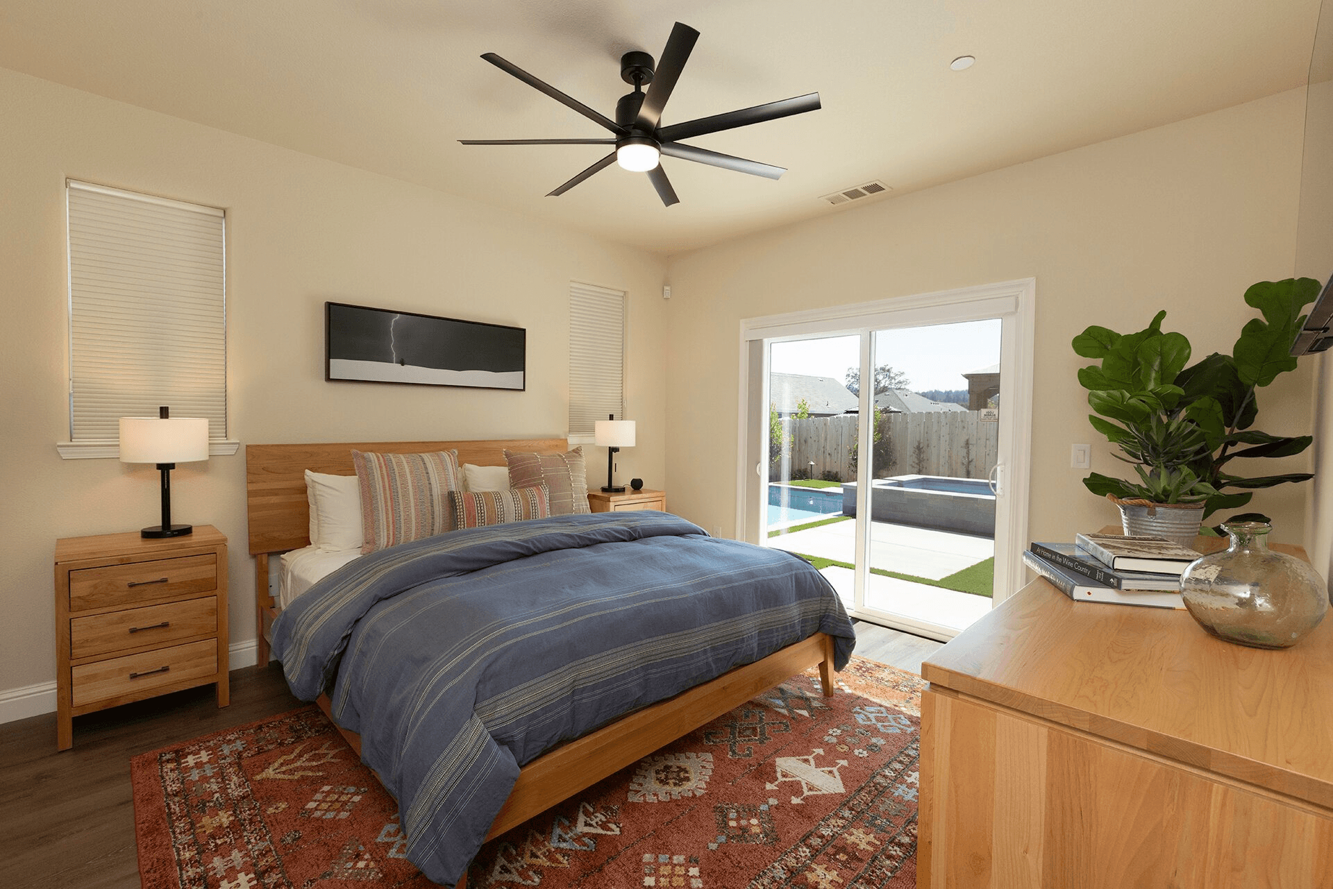 Modern bedroom with a king-sized bed, natural light, and a sliding glass door leading to an outdoor area.
